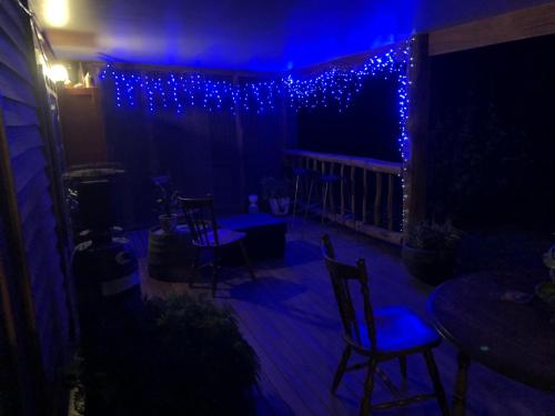 YeaStarlight Lodge的露台配有蓝色的灯光和椅子以及桌子