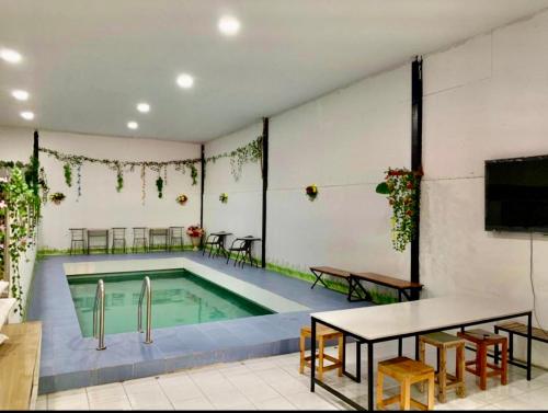 格兰岛Cactus Resort的游泳池位于带桌椅的房间