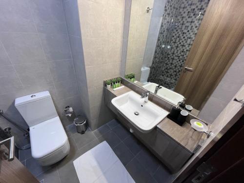 迪拜Super Studio in Dubai的浴室配有白色卫生间和盥洗盆。