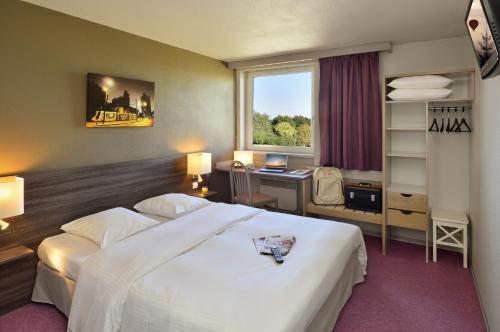 奥特马塞姆艾尔斯酒店的配有一张床、一张书桌和一扇窗户的酒店客房