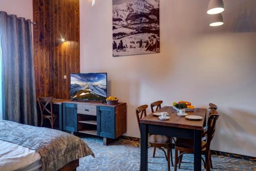 迪马诺卡多林纳Strachan Family Jasná的酒店客房设有床、桌子和电视。