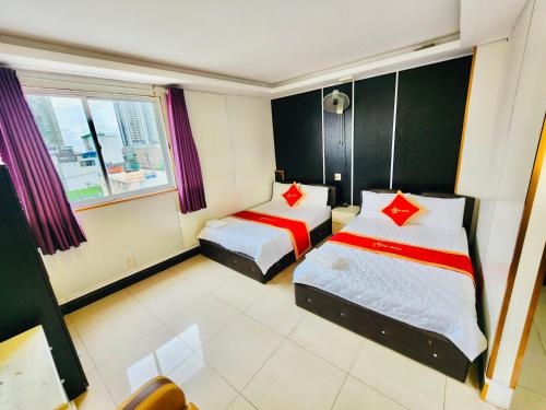胡志明市Istars Hotel的酒店客房设有两张床和窗户。