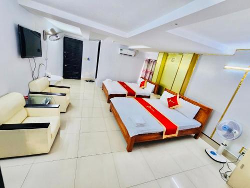胡志明市Istars Hotel的酒店客房,设有两张床和一张沙发