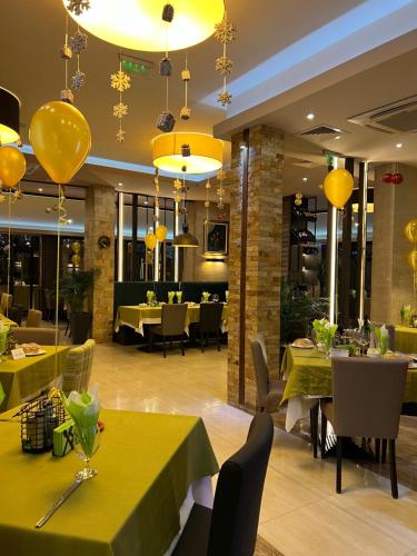 奥格尼亚诺沃Family Hotel Ognyanovo的餐厅设有黄色桌椅和黄色吊灯