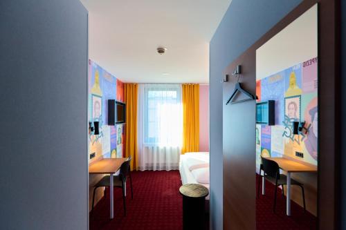 莱比锡莱比锡麦克梦想酒店的酒店客房带一张床、两张书桌、一张床和一个房间