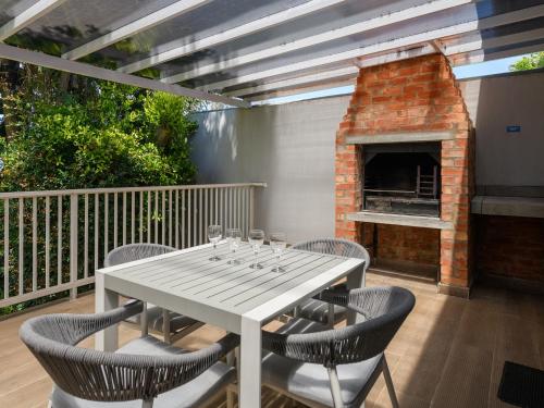 普利登堡湾福尔摩沙海湾度假村的带壁炉的庭院配有桌椅