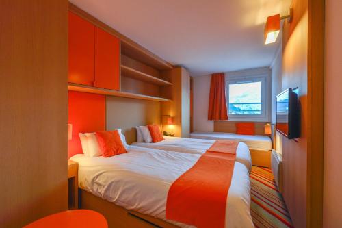 莱德萨阿尔卑斯Villages Clubs du Soleil - LES 2 ALPES的一间酒店客房,配有一张床和一台电视