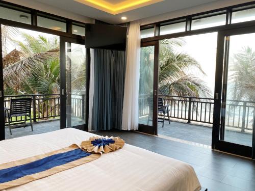 潘切Starlight Villa Beach Resort & Spa的一间卧室设有一张床,阳台设有滑动玻璃门