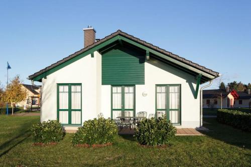 马克莱贝格Holiday home in Markkleeberg near a lake的一间白色的小房子,配有绿色百叶窗