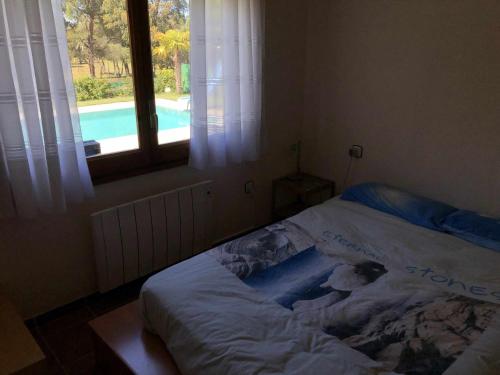 卡尔德斯德马拉维亚Casa Bellavista con piscina en Caldes Costa Brava的卧室内的一张床位,卧室设有窗户和游泳池