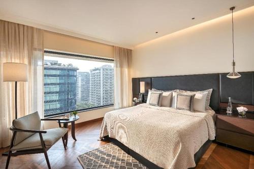 孟买孟买欧贝罗伊酒店的卧室配有床、椅子和窗户。
