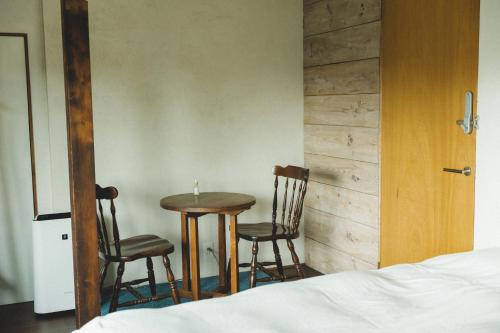 SetoMasukichi 古民家宿ますきち 駐車場無料的一间卧室配有桌子、两把椅子和一张床