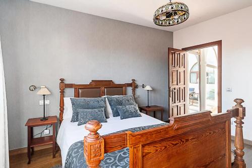 特罗尔Casa típica canaria en el Parque Rural de Doramas的一间卧室配有一张带蓝色枕头的木床。
