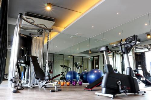 曼谷Cinnamon Hotel Bangkok的健身房,配有许多健身器材和镜子