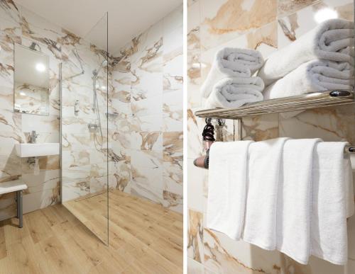 考纳斯阿尔基罗酒店的一间带白色毛巾和淋浴的浴室