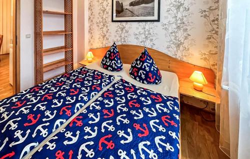 StubbenfeldeStunning Apartment In Klpinsee-usedom With Kitchen的一间卧室配有一张带蓝色和红色床单及枕头的床。
