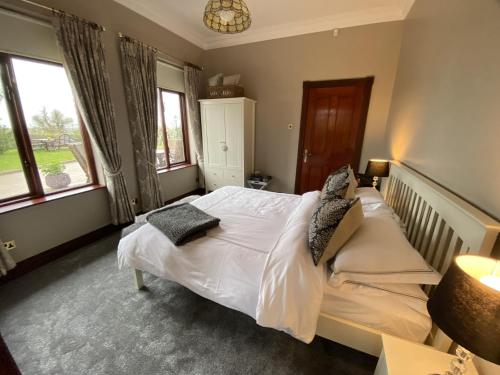 卡斯尔贝灵汉Ravenwood的一间卧室配有带白色床单和枕头的床。