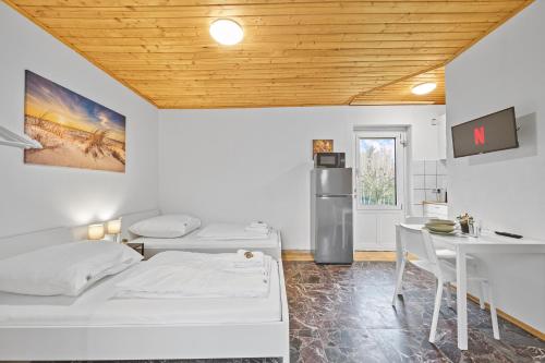 德根多夫home2stay Apartmenthaus Deggendorf Wifi Smart TV Parking***的客房设有两张床、一张桌子和一台冰箱
