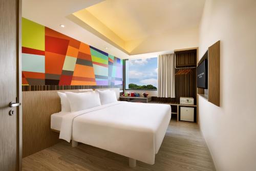新加坡Genting Hotel Jurong的卧室配有白色的床和色彩缤纷的墙壁