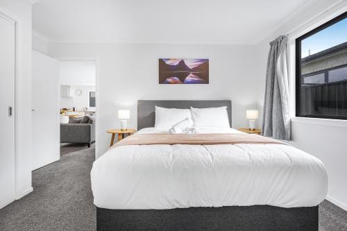 汉密尔顿Modern Retreat with King Bed - By KOSH BNB的一间卧室设有一张大床和一个窗户。