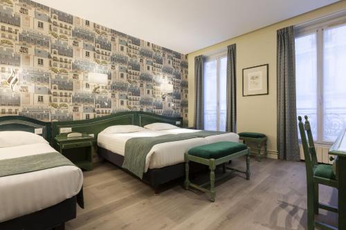 巴黎杜普雷酒店的一间卧室设有两张床,墙上挂着照片