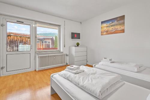 德根多夫home2stay Apartmenthaus Deggendorf Wifi Smart TV Parking***的白色的客房设有两张床和窗户。
