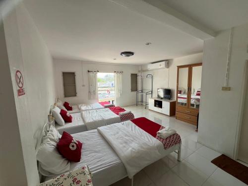 华欣OYO 908 Sabai Place的一间卧室配有两张带红色枕头的床