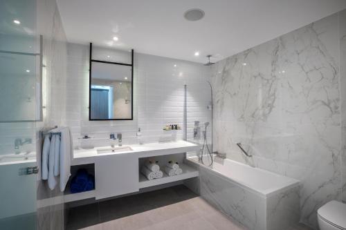 普罗塔拉斯卡沃马里斯海滩酒店的白色的浴室设有浴缸和水槽。