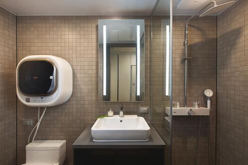 釜山Haeundae Youngmu Parade Hotel的一间带水槽、卫生间和镜子的浴室