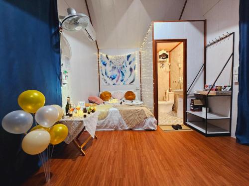 木州县Homstay Mimosa Mộc Châu的一间卧室配有一张床和一张带气球的桌子。