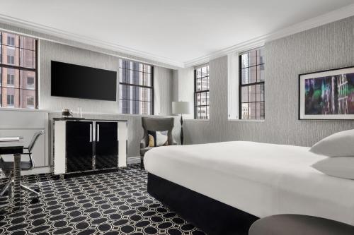 纽约The Muse New York的一间酒店客房,配有一张大床和一台平面电视