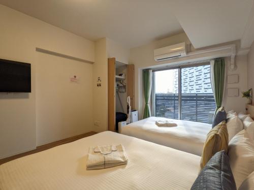 大阪ESLEAD HOTEL Osaka Ebisu的酒店客房设有床和窗户。