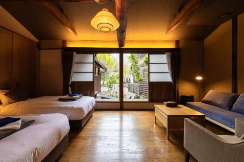 MimaPAYSAGE MORIGUCHI的客房设有两张床、一张沙发和一个窗口。