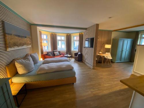 奥斯赛拜-屈隆斯博恩Hotel von Jutrzenka的一间设有床铺和客厅的房间