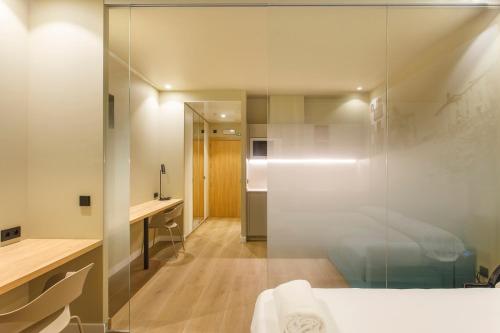潘普洛纳Hotel Landaben的一间带玻璃淋浴间和一张床的卧室