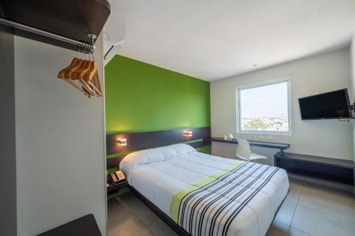 托卢卡City Express Junior by Marriott Toluca Zona Industrial的一间卧室设有一张床和绿色的墙壁
