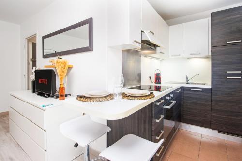 博索莱伊5 mn à pied Monaco - Cosy appartement的厨房配有白色的柜台和白色的椅子