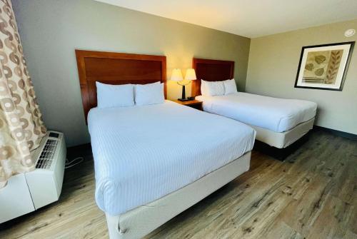 埃尔斯沃思Hawthorn Extended Stay by Wyndham Ellsworth Bar Harbor的酒店客房,配有两张带白色床单的床
