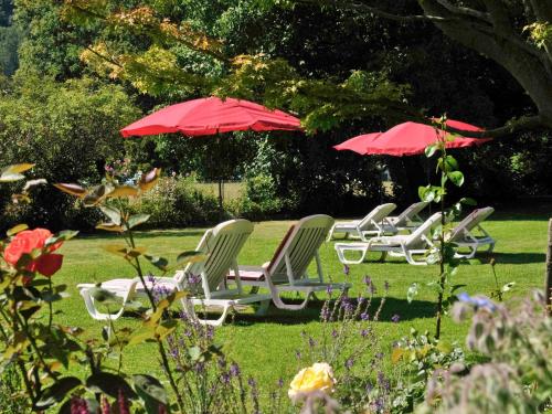 因特拉肯Hotel Royal St Georges Interlaken MGallery Collection的院子里一群草坪椅和遮阳伞