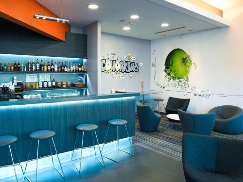 凯恩卡昂中心火车站宜必思样尚品酒店的一间设有蓝色凳子的餐厅内的酒吧