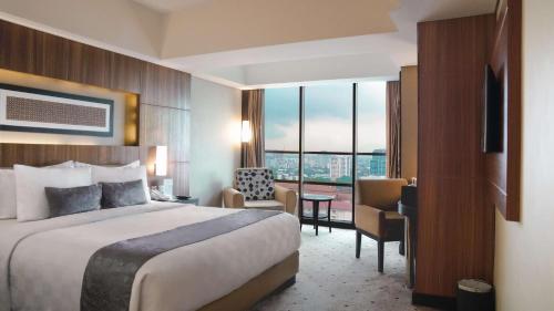 万隆贝斯特韦斯特高级万隆大酒店的配有一张床和一张书桌的酒店客房