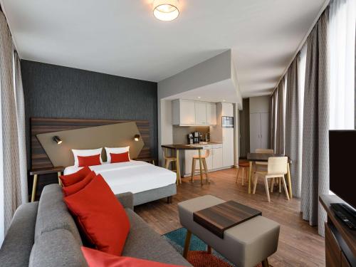 不莱梅Aparthotel Adagio Bremen City的酒店客房,配有床和沙发