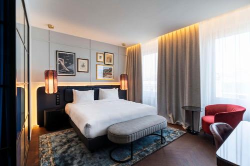 米兰Radisson Collection Hotel, Santa Sofia Milan的酒店客房,配有一张床和一张红色椅子