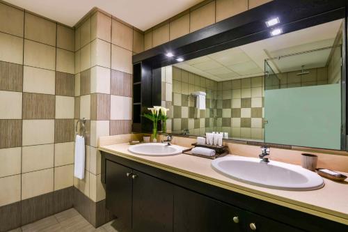 多哈凯宾斯基的一间带两个盥洗盆和大镜子的浴室
