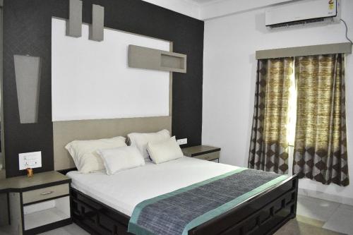 迪马普尔MAYUR HOTEL的一间卧室设有一张大床和一个窗户。