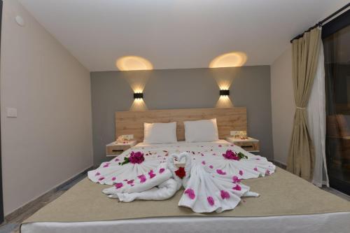 马尔马里斯TRAKHEİA OTEL的一间卧室配有一张带鲜花的大床