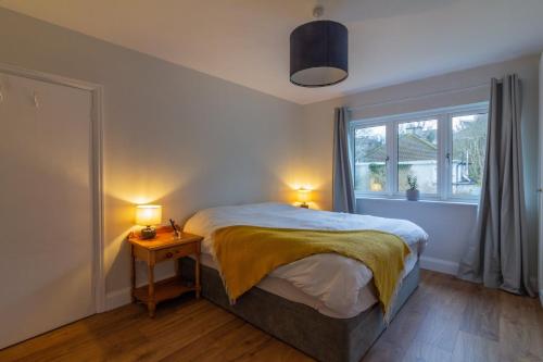 都柏林GuestReady - Serene Haven near Castle Golf Club的一间卧室配有一张床、一个窗口和两盏灯。
