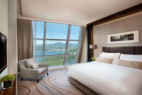 怀柔北京日出东方凯宾斯基酒店的一间卧室配有一张床、一把椅子和一个大窗户