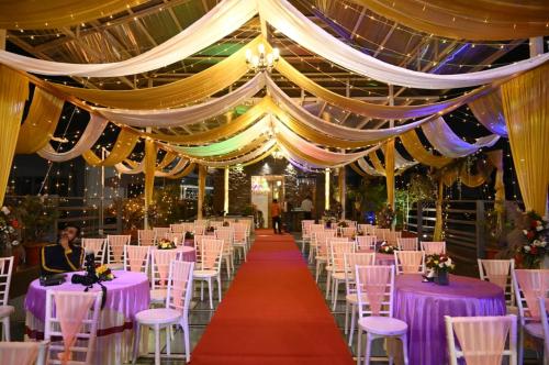 古瓦哈提HOTEL SHOOLIN GRAND的宴会厅配有紫色的桌椅