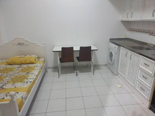 沙迦Furnished Studio for Rent的厨房配有床和桌椅